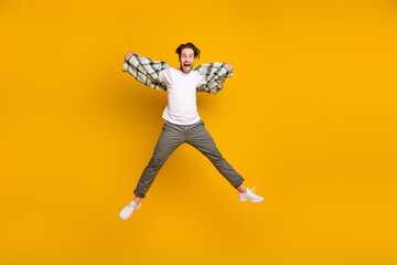 Fototapeta na wymiar Full length photo of young excited man amazed shocked yell jump up isolated over yellow color background
