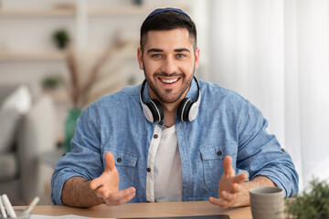 Cheerful man having video call using laptop and talking