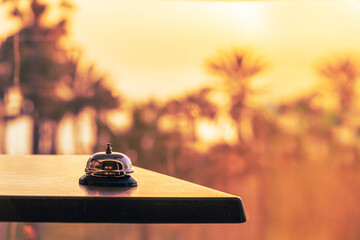 Hotel service bell against the background of coastline sea and palm tree on sunset. Travel concept....