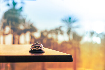 Hotel service bell against the background of coastline sea and palm tree on sunset. Travel concept....