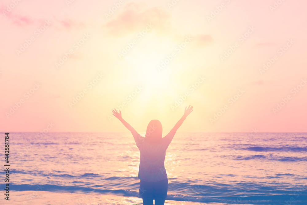 Wall mural copy space of woman rise hand up on sunset sky at beach and island background.