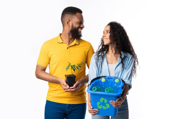 Couple Holding Plant And Bucket With Recycling Waste, White Background
