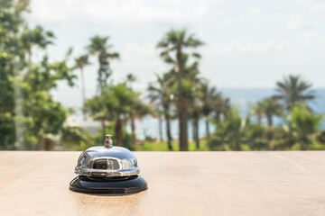 Hotel service bell against the background of coastline sea and palm tree. Travel concept. Summer beach hotel front desk.