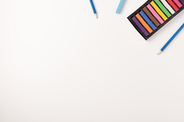 Colorful wax crayons and pencils isolated on white background. Copy space. Top view.