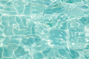 Transparent sea with turquoise water and glare of the sun on the surface.