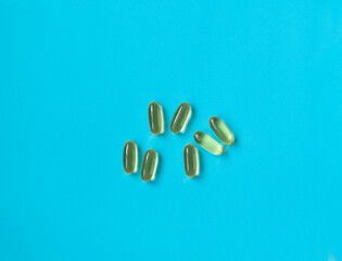 Fish oil capsules on a blue background