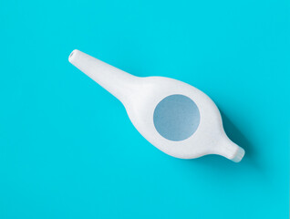 Neti pot for nasal rinsing on a blue background,  sinus rinse, health, treatment for congestion.