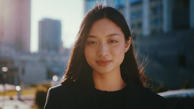 Young beautiful asian thai woman with lovel black hair standing on the street. Outdoor girl portrait in modern cityscape background.