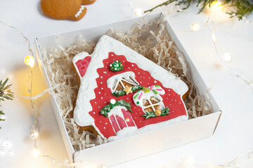 Christmas composition, postcard, calendar. Gingerbread in the form of a house in a package on a light background. Edible handmade souvenirs. The concept of New Year's gifts. Copy space. Flat lay