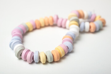Closeup of pastel necklace candies on white background