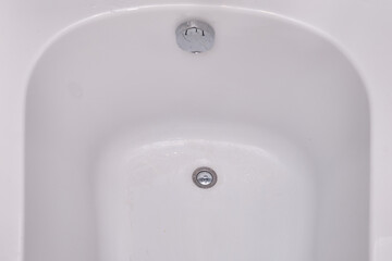 Clean white bath bowl with drain hole, close up