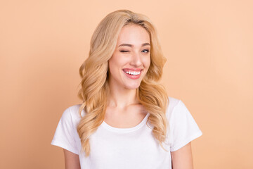Photo portrait blonde woman winking blinking smiling happy isolated pastel beige color background