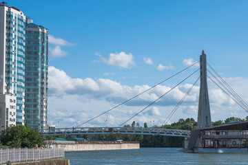 Cable-stayed bridge over the Kuban River and a multi-storey house on the embankment. Urban landscape