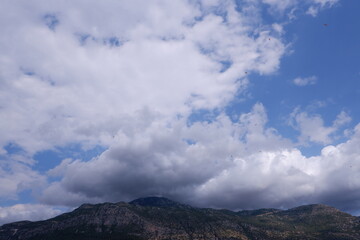 Obraz premium hills view with clouds paragliders flying 