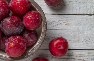 Plum on a dark and light wooden background.