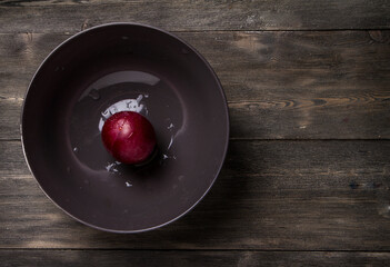 Plum on a dark and light wooden background.