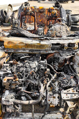 Obraz premium Burned-out car after arson accident. Melted plastic in a fire.