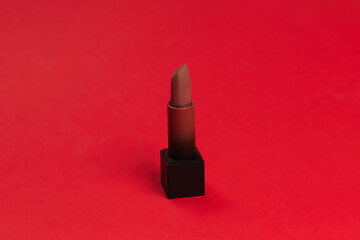 Red lipstick on a red background. Makeup.