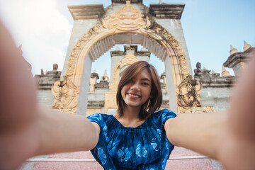 Young Asian woman happy smile selfie with attractions pagoda of the buddhism. Trip travel in...