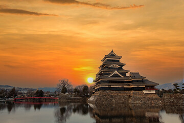 Old castle in japan. Matsumoto castle against sunset sky in Nagono city, Japan. Castle in Winter. Travel Matsumoto Castle with frozen pond in Winter. A Japanese premier historic castles