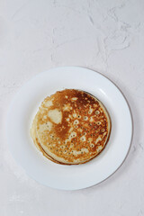 Pancakes in a snow-white plate. Rosy hot sweet breakfast.