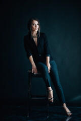 Beautiful woman sits on a chair and looks at you