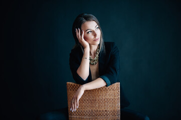 Beautiful woman sits on a chair and looks out the window