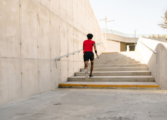 Athletic man running and doing exercise outdoors.