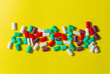 Multi-colored chewing gum on a yellow background