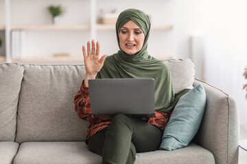 Muslim Lady In Hijab Video Calling Waving To Laptop Indoor