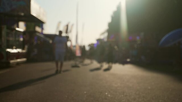 People walk down the street in summer. Blurred shot.