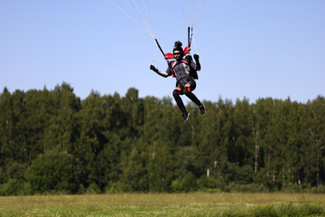 Fototapeta na wymiar Skydiving. The girl is piloting a parachute and landing.
