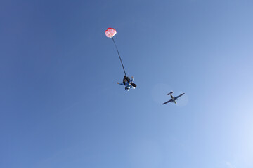 Naklejka na ściany i meble Skydiving. Tandem jump. A barefoot girl is flying in the sky.