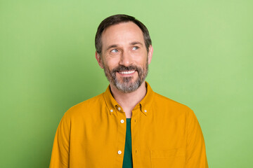 Fototapeta premium Photo of aged man happy positive smile dream think curious look empty space isolated over green color background