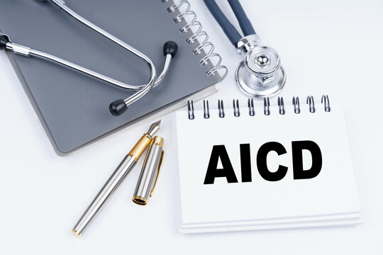 On the table are a stethoscope, a pen and a notebook with the inscription - AICD