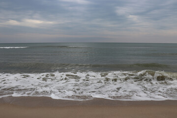 The sea coast at sunset. Sandy beach. A good place to relax with the whole family.
