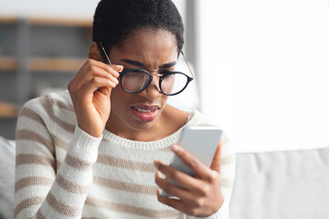 Bad Vision. Young African American Woman In Eyeglasses Looking At Smartphone Screen - obrazy, fototapety, plakaty