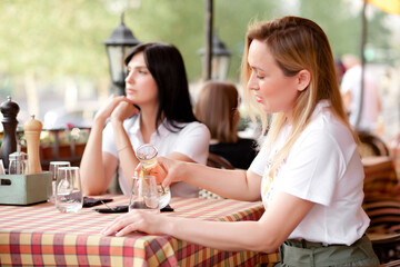 Women sitting at cafe terrace. Communication and friendship concept.