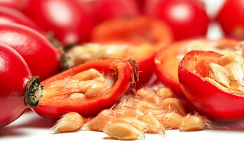 Rosehips Rosa Canina fruits ,cut in half seeds visible macro closeup detail, isolated on white...