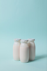 Bottles with probiotics and prebiotics dairy drink on light blue background. Bio yogurt with useful...