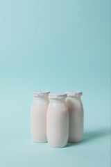 Bottles with probiotics and prebiotics dairy drink on light blue background. Bio yogurt with useful microorganisms. Production with biologically active additives. Fermentation and diet healthy food.