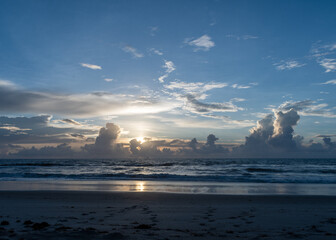 Beautiful sunrise at the beach with pretty clouds and blue sky