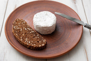Grain bread and blue cheese on a brown clay plate. Cooking snacks.