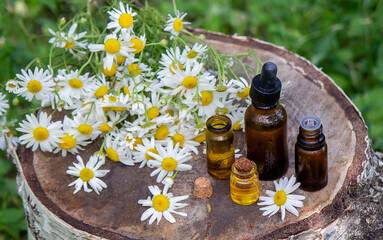 chamomile essential oil on a wooden background.