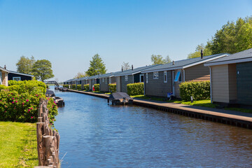 Giethoorn, Netherlands, May 30, 2021. Tourist cabins near the famous village of Giethoorn in the Netherlands with traditional dutch houses, gardens and water canals and wooden bridges.