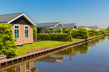 Giethoorn, Netherlands, May 30, 2021. Tourist cabins near the famous village of Giethoorn in the Netherlands with traditional dutch houses, gardens and water canals and wooden bridges.