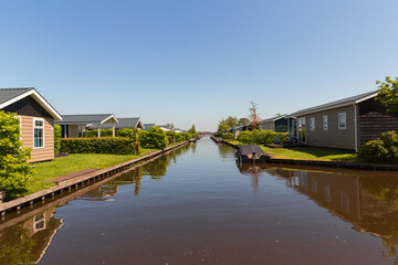 Fototapeta na wymiar Giethoorn, Netherlands, May 30, 2021. Tourist cabins near the famous village of Giethoorn in the Netherlands with traditional dutch houses, gardens and water canals and wooden bridges.