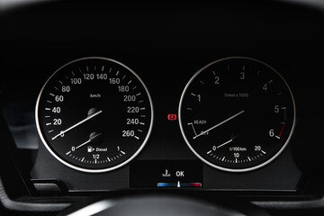 Speedometer arrows in dark colors in a car.