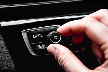 Hand tuning multimedia button in car panel.