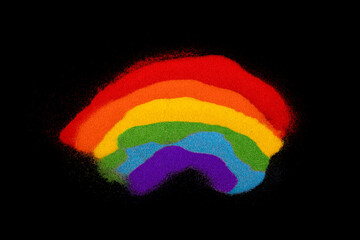 Colorful rainbow made of colored sands on black background